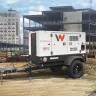 White Wacker-Neuson 38 kW towable generator parked at a commercial construction site