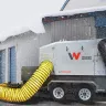Radiateur à combustion indirecte Wacker-Neuson de 1 000 000 BTU gris stationné dans la neige à l’extérieur d’un entrepôt