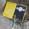 Panneau de commande d’essai pneumatique Cherne jaune et noir ouvert et posé sur un sol rocheux avec des câbles connectés