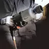Silver and black Ingersoll Rand 1 inch drive Air Impact Wrench with a d-handle being held by a worker