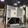 Refroidisseur refroidi à l’air Trane de 100 tonnes blanc monté sur une mini-chargeuse dans un entrepôt
