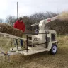 Beige and black FinnCorp straw blower gas powered used by a man on the field