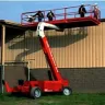 orange telescopic boom lift extended on exterior wall of building