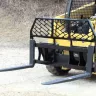 yellow skid steer using a fork attachment on a jobsite